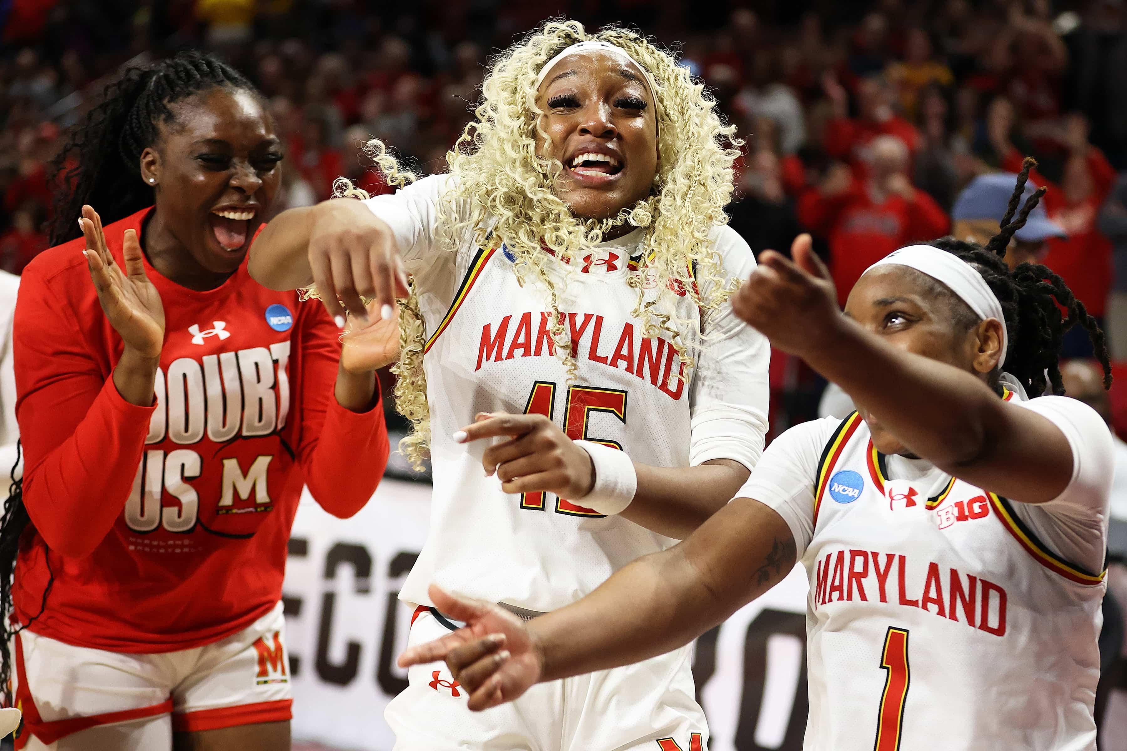 A group of women's basketball players celebrate after a win.