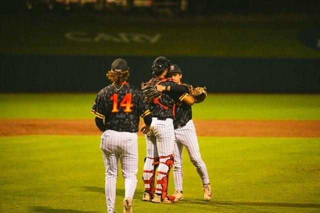 The Tampa Spartans pitcher and catcher embrace on the mound as they chase another DII baseball championship.